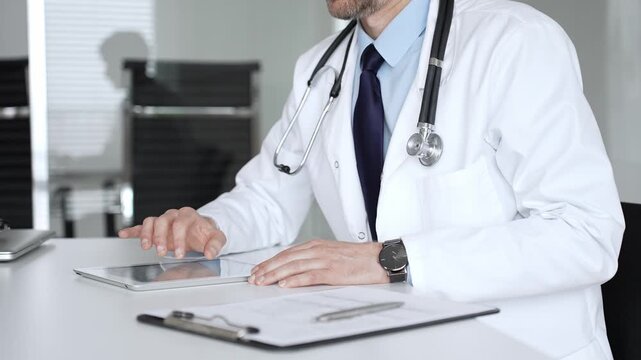 Male doctor communicating with patient at a clinic desk, offering professional healthcare guidance and explaining a diagnosis. Medicine, healthcare and science concept
