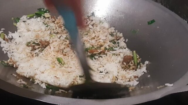 Close-up video of cooking rendang fried rice (nasi goreng rendang), a flavorful Indonesian dish combining aromatic spices and rich rendang meat with stir-fried rice. 