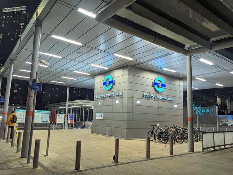 Sleek illuminated entrance to Stratford International DLR station at night in East London, UK