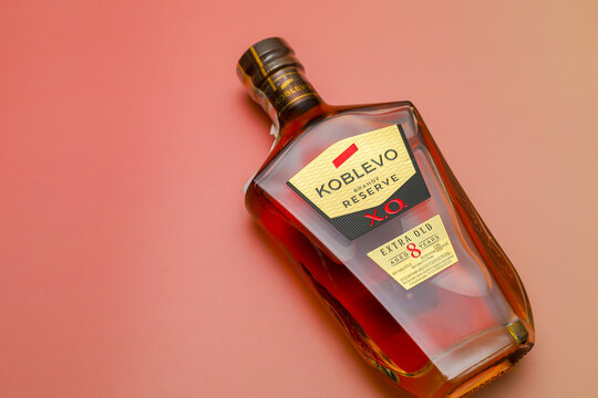 Lviv, Ukraine - March 25, 2026: A bottle of premium brandy with an exquisite golden label lies on a soft peach background.
