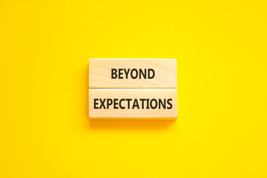 Beyond expectations words symbol. Concept words Beyond expectations on beautiful wooden blocks. Beautiful yellow background. Business and Beyond expectations words concept. Copy space.