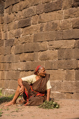 Fototapeta premium Senior woman working in front stone wall