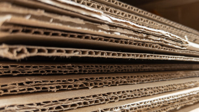 Stacked corrugated cardboard sheets revealing layered wavy flute structure in close-up 