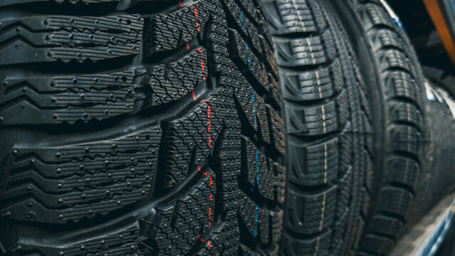Dark rubber tread surface of winter tires: angular blocks, channels, and micro-texture detail
