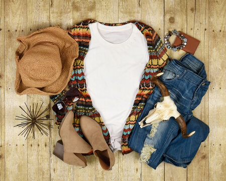 A white t-shirt clothing flatlay with various fashion boho accessories and boots for a woman's trend. ou Add your design to the blank copyspace area of the shirt.