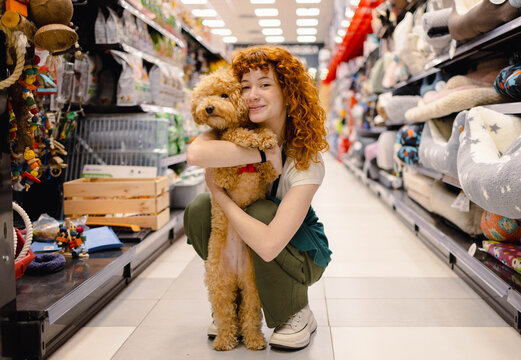 Young Woman and Poodle Having Fun in Pet Store