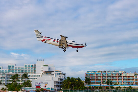 St. Barth Executive Pilatus PC-12 NGX flying over Maho Beach before landing on Princess Juliana International Airport SXM on Sint Maarten, Dutch Caribbean. 