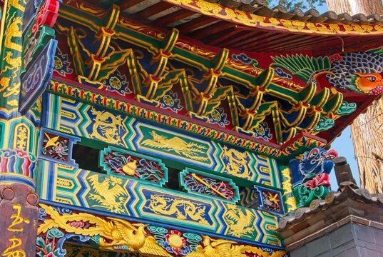 Intricate colorful traditional temple entrance patterns in Baisha Village. Detailed geometric, floral and fauna motifs highlighting ancient architecture.