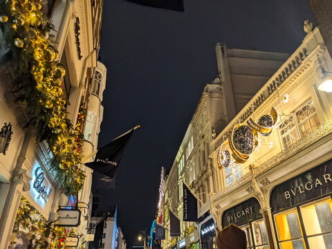 Illuminated luxury boutiques and festive gold Christmas lights along New Bond Street in London