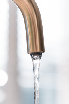 Kitchen faucet close-up with running water, kitchen sink and tap