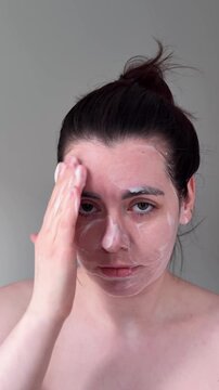 Woman Performing Relaxed Skincare Routine Using Circular Massage To Apply Facial Cleanser At Home