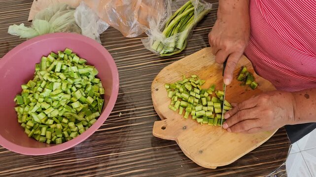 Close up of hands chopping green cactus pads