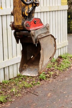 Close-up of a small yellow excavator bucket at a construction site.