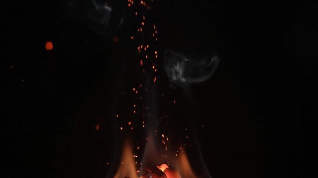 Glowing embers and sparks rising from a fire in a dark environment with a warm, fiery mood.
