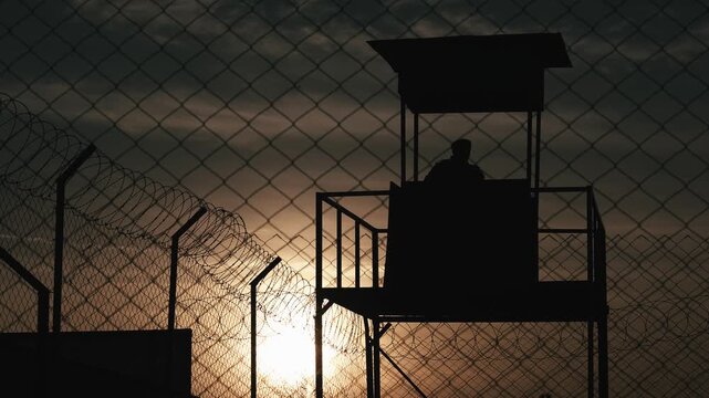 Prison Wall with Guard Tower Silhouette. Military seclusion and restricted areas video.