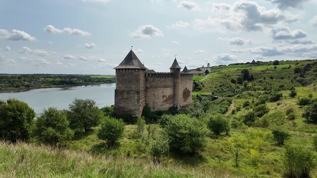 Wide panoramic view of Khotyn Fortress filmed from a distant hill, showing defensive slopes and the Dniester River below. Camera moves smoothly from left to right, emphasizing scale and landscape.