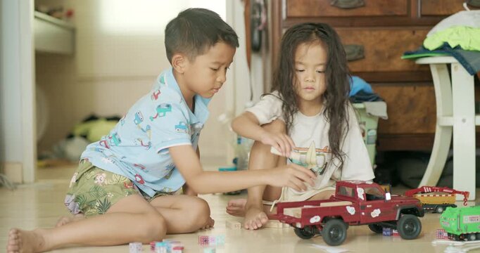 Adorable littl shcool boy enjoy play car toy with block building in cozy room education concept