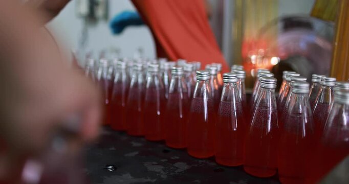 At beverage bottles line, focused workers systematically organizes the bottles into a large container. then staged at the loading dock, ready for distribution in beverage drinking water factory