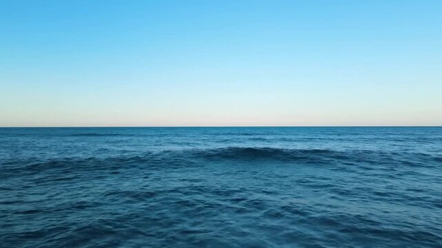 Calm turquoise ocean waves gently rolling under a bright blue sky with scattered clouds a serene seascape evoking peace and tranquility for travel wellness or coastal branding