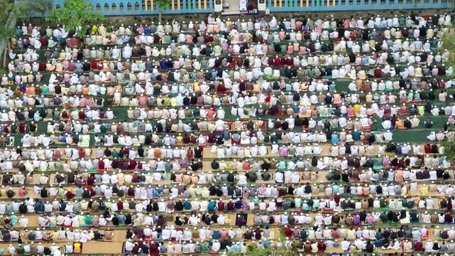 Muslim people kneeling during outdoor eid prayer in bangladesh