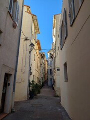 Obraz premium Charming narrow street in Antibes with blue sky, mediterranean background with copy space for travel and lifestyle concepts