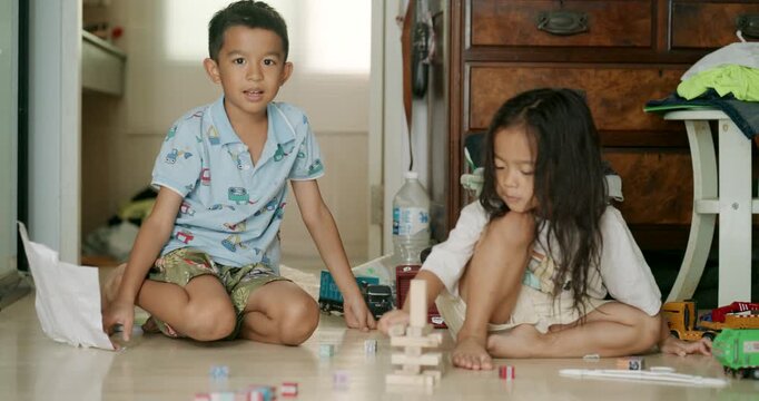 Little asian kids boy and girl enjoy play toy car fix repair in cozy room kids education