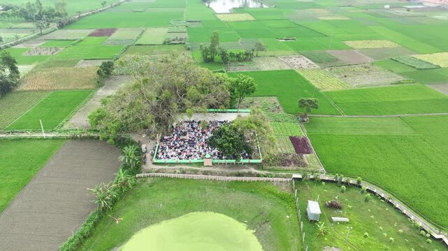 Muslim people praying together in a rural outdoor mosque