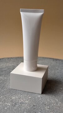 A white empty plastic or aluminum tube for cream, paste, gel, or shampoo as a mockup. An empty cosmetic tube mockup as a background for your design