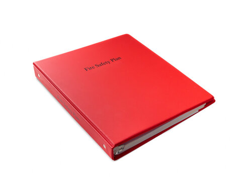 Fire safety plan binder. Red binder with emergency instructions, equipment location and contacts. Required for residential and commercial buildings in British Columbia. Selective focus.