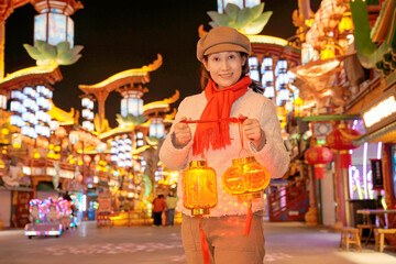Obraz premium Woman Holding Lanterns at Festive Night Market