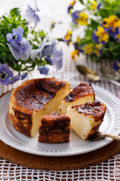 Basque cheesecake portioned on a white plate, close-up view
