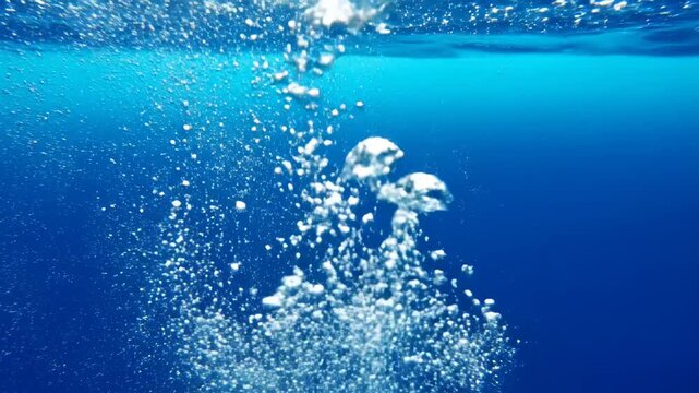 Refreshing Underwater Bubbles rising through deep blue ocean water towards the surface ideal for nature documentaries and wellness backgrounds.