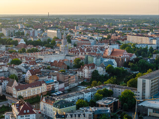 Lotniczy widok na zabytkowe centrum Opola podczas zachodu słońca. Widać Ratusz i kościół franciszkanów. Panorama miasta z Młynówką i mostami w ciepłym, złotym świetle wieczornym. © Henryk Niestrój