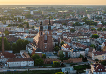 Lotniczy widok na zabytkowe centrum Opola podczas zachodu słońca. Widać Ratusz i kościół franciszkanów. Panorama miasta z Młynówką i mostami w ciepłym, złotym świetle wieczornym. © Henryk Niestrój