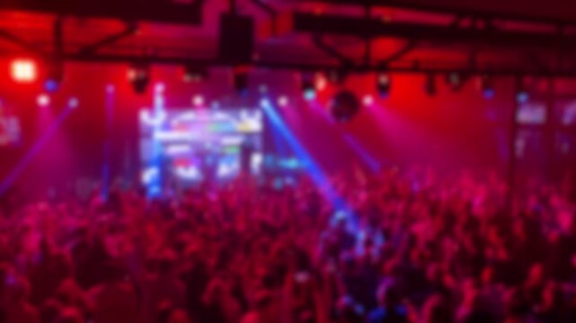 Blurred out-of-focus crowded live concert inside a club.