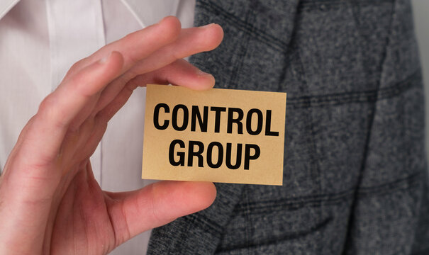 Person holding a yellow card with Control Group text, representing scientific research, clinical trials, and data analysis.