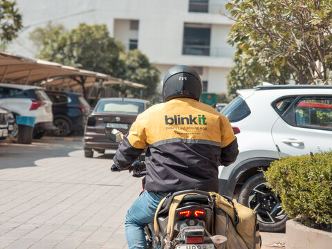 Delhi, India - 15th feb'26 : Hyperlocal delivery rider wearing Blinkit jacket on motorcycle, representing quick commerce, last minute grocery delivery, and app based logistics in Indian city.