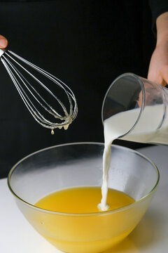 Creamy Dessert Preparation. Artisan Chef Skillfully Whisks Milk Into Luscious Custard In Glass Bowl