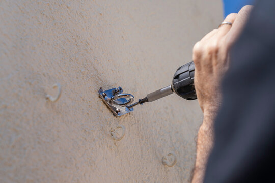 An unrecognizable person installing a support bracket for an outdoor awning on their penthouse terrace.
People, lifestyles, DIY projects