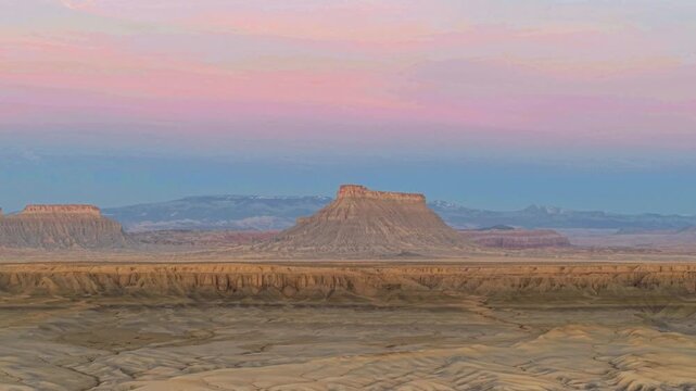 Pano view of UTAH Factory Butte in dawn. Colorful pink skies in background and desert landscape. 