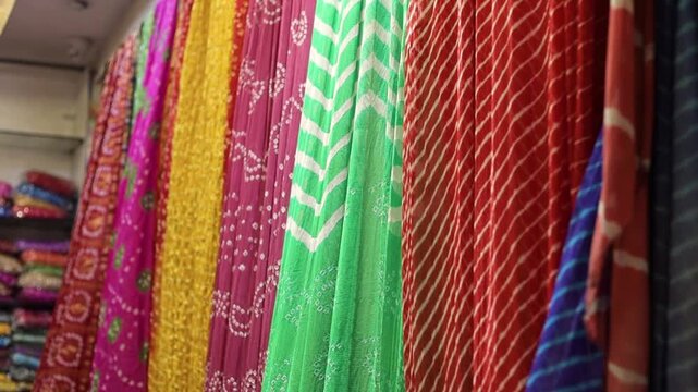 Colourful sarees hanging on display inside a shop