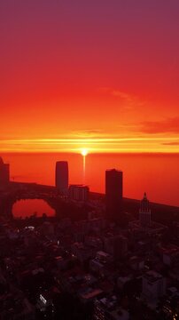 batumi, georgia, sunset, vertical video, aerial, drone, black sea, city, skyline, red sun, golden hour, horizon, buildings, urban, travel, tourism, scenic, landscape, evening, sky, clouds, vibrant, ci