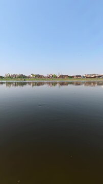 Indian jamuna scenic view of a river with a cityscape on the horizon 4k stock vertical video footage.