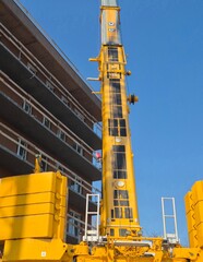 Rear view of a 450-ton mobile crane featuring massive counterweights and details of the extended boom on a construction site. © Mevhis