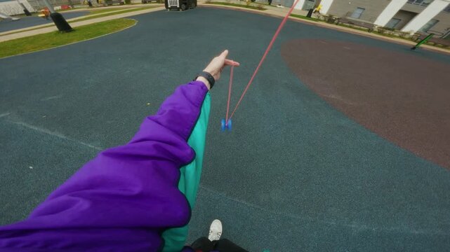 Hands spinning a toy on a string. Yo-Yo game, first-person view.