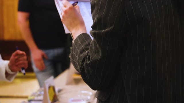 Process of checking in on conference congress forum event, registration desk table, visitors and attendees receiving lanyard with name badge and entry wristband bracelet and register electronic ticket