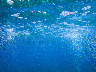 Naklejka premium Ocean blue underwater with sunrays, Underwater Sea Deep Water Abstract Sunshine, sea wave , clean waters in summer time, Natural underwater seascape, sand on ocean floor and water surface sunlight.