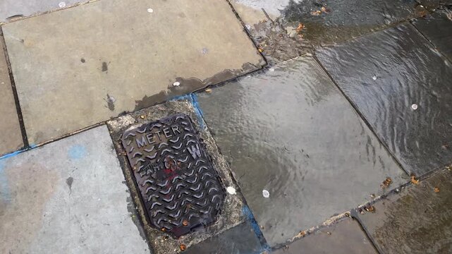 London UK, March 28th 2026: Water pouring out from a man hole cover. Underground pipe water leak. Pan right to left, 4K. 