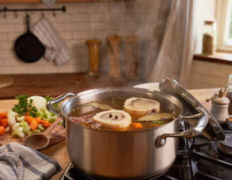 A steaming pot of bone broth with marrow cooking in a cozy kitchen.
