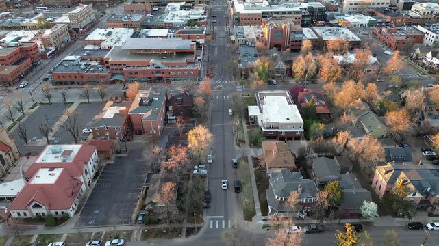 Downtown Boulder blocks near Pearl and Walnut Street form tight grid transitioning toward residential by Front Range foothills. Warm light flat roofs, pitched shingles, bare trees, brick textures